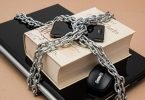 Book, phone, laptop bound with chains